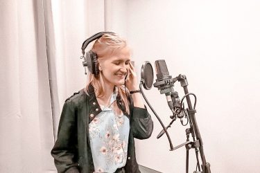 dziewczynka w studio nagraniowym śpiewa do mikrofonu
